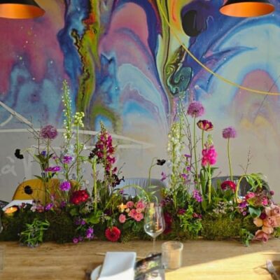 Farbenfrohe florale Tischdekoration mit Moos und Kerzen