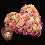 Herzförmiges Blumengesteck in Rosa, Apricot und Flieder mit Windlicht