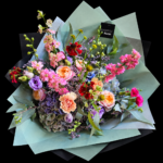 Blumenstrauß Bunte Freude – Ein bunter, locker gestalteter Blumenstrauß in Rosa, Apricot, Flieder und Blau mit Rosen, Nelken, Hortensien und aufstrebenden Blüten.