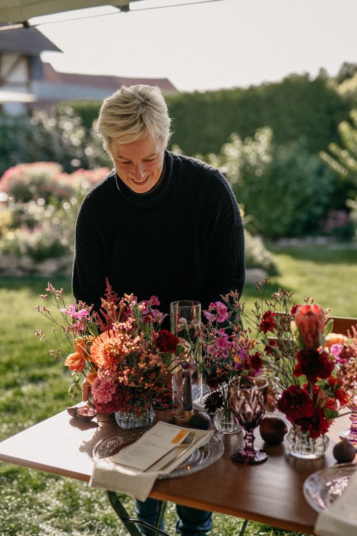 Uta beim Gestalten eines floralen Tischarrangements.